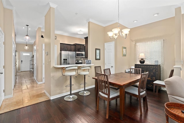 dining space featuring crown molding, dark wood-type flooring, and a chandelier