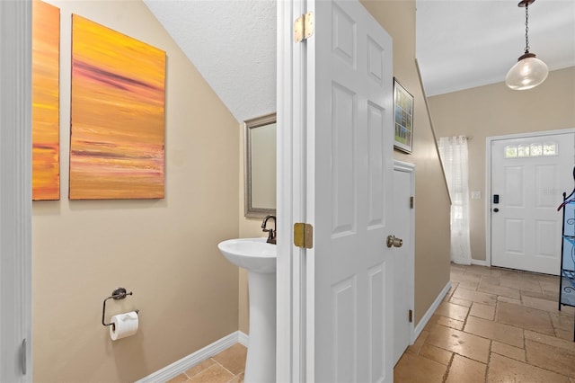 bathroom with a textured ceiling and vaulted ceiling