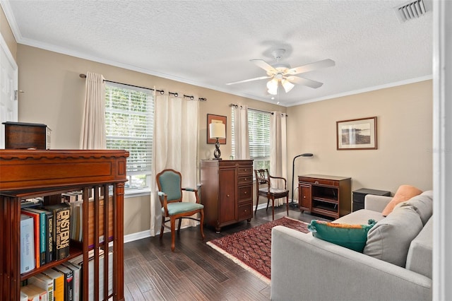 living room featuring ceiling fan, dark wood-type flooring, a textured ceiling, and ornamental molding