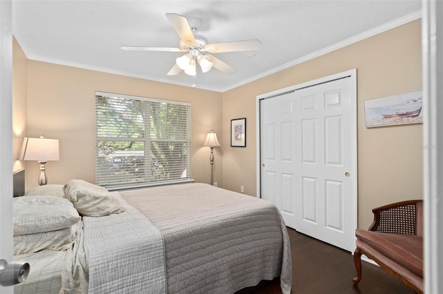 bedroom with dark hardwood / wood-style flooring, ceiling fan, a closet, and ornamental molding