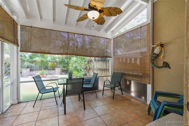 sunroom / solarium with ceiling fan and lofted ceiling with beams