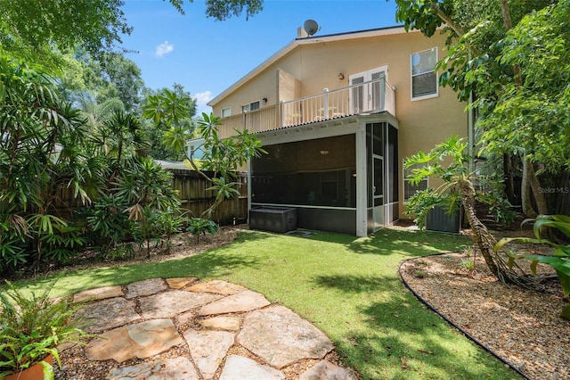 view of yard featuring a sunroom and a balcony