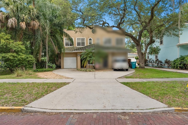 mediterranean / spanish home with a garage and a front lawn