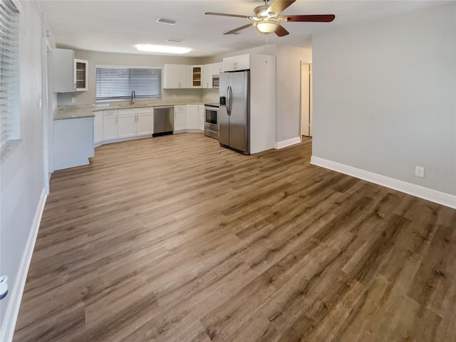 kitchen with light hardwood / wood-style flooring, sink, white cabinetry, appliances with stainless steel finishes, and ceiling fan