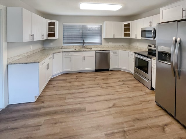 kitchen featuring sink, white cabinets, light hardwood / wood-style flooring, and stainless steel appliances