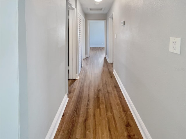 hallway with hardwood / wood-style flooring