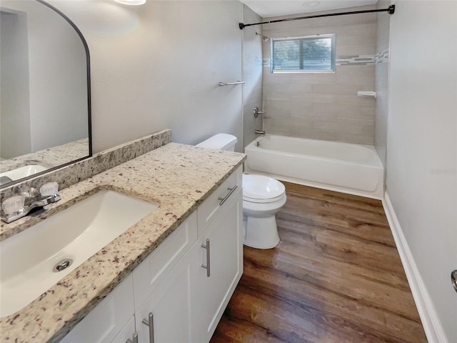 full bathroom with toilet, tiled shower / bath, vanity, and wood-type flooring