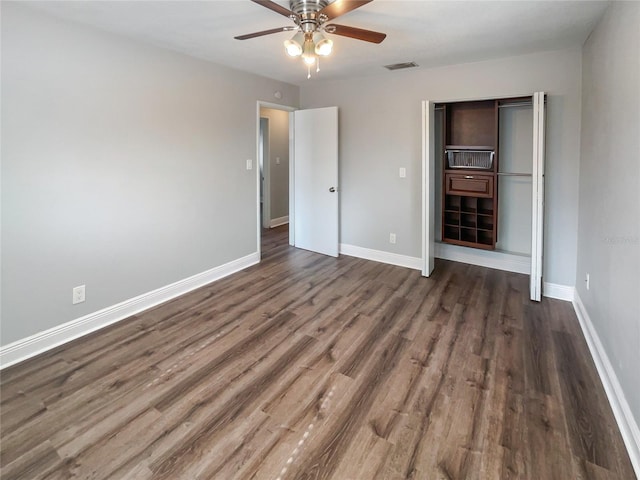 unfurnished bedroom with dark wood-type flooring, a closet, and ceiling fan