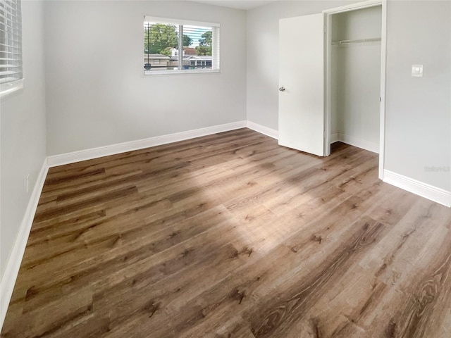 unfurnished bedroom with a closet and dark hardwood / wood-style flooring