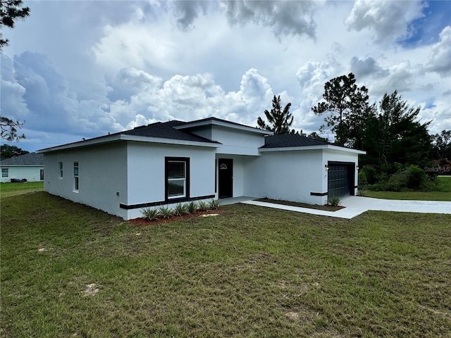 view of front of home featuring a front yard, a garage, driveway, and stucco siding