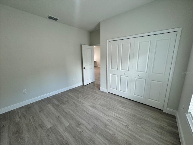 unfurnished bedroom featuring a closet and wood-type flooring