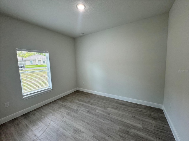 spare room featuring hardwood / wood-style flooring and a textured ceiling