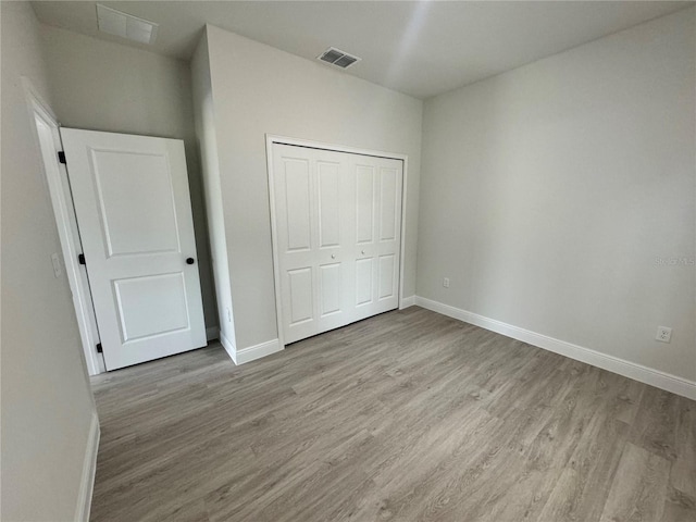 unfurnished bedroom with a closet and hardwood / wood-style floors