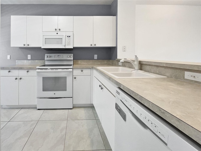 kitchen featuring white cabinetry, sink, light tile patterned flooring, and white appliances