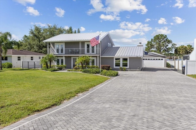 view of front facade featuring a garage, a balcony, and a front lawn