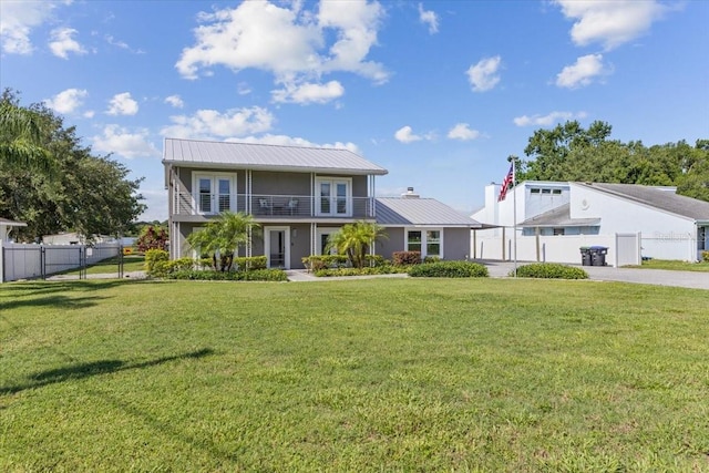 view of front of home featuring a balcony and a front lawn