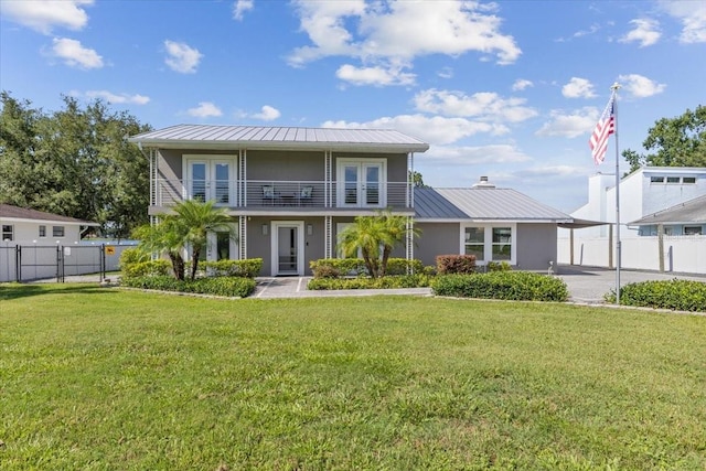 view of front of property with a balcony, a front lawn, and a carport