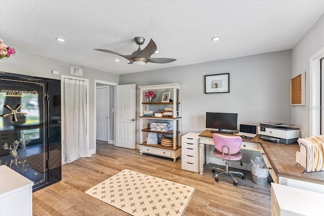 office space with ceiling fan, light wood-type flooring, and a textured ceiling