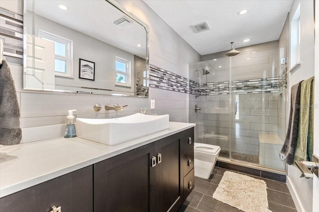 bathroom with walk in shower, a textured ceiling, toilet, decorative backsplash, and vanity