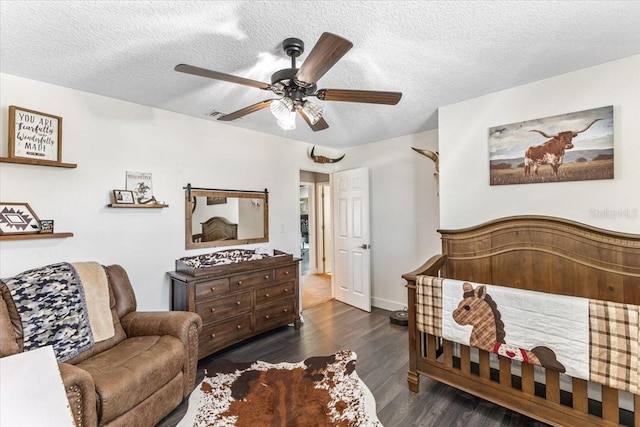 bedroom with ceiling fan, dark hardwood / wood-style floors, and a textured ceiling