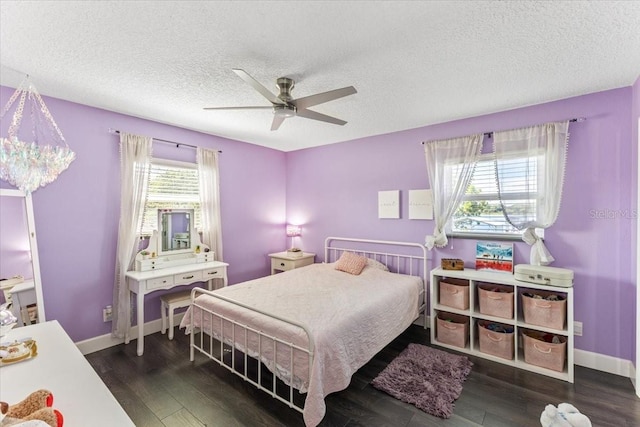 bedroom with multiple windows, a textured ceiling, dark hardwood / wood-style flooring, and ceiling fan