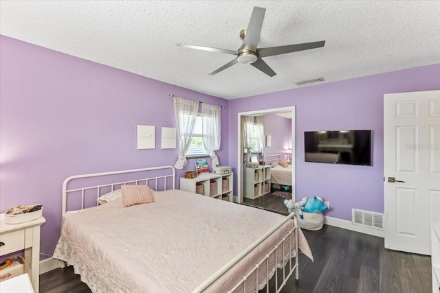 bedroom featuring a textured ceiling, dark hardwood / wood-style floors, and ceiling fan