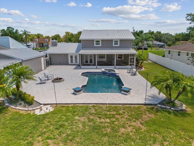 back of house featuring a yard, a fenced in pool, a fire pit, and a patio area