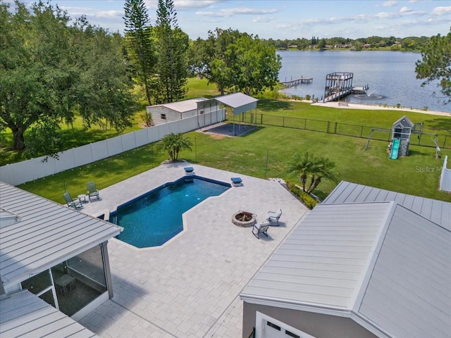 view of pool with a lawn, a water view, an outdoor fire pit, and a patio