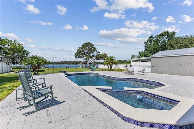 view of swimming pool featuring an in ground hot tub, a yard, a water view, and a patio area