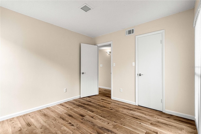 unfurnished bedroom with hardwood / wood-style flooring