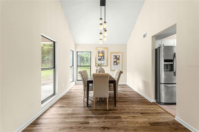 dining room featuring high vaulted ceiling and dark hardwood / wood-style flooring