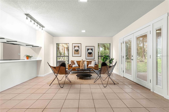 living area featuring a textured ceiling, light tile patterned floors, and french doors