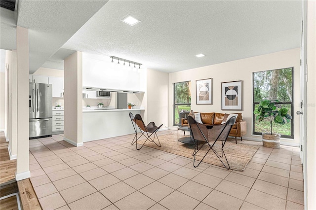 tiled dining area featuring a textured ceiling