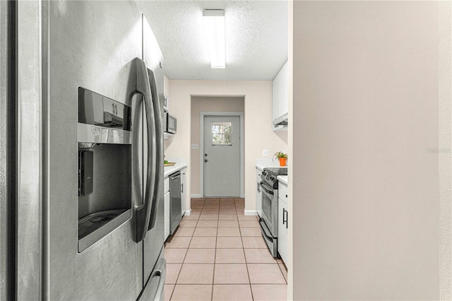 kitchen featuring light tile patterned flooring, appliances with stainless steel finishes, a textured ceiling, and white cabinets