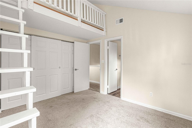 unfurnished bedroom with carpet, a closet, and a towering ceiling