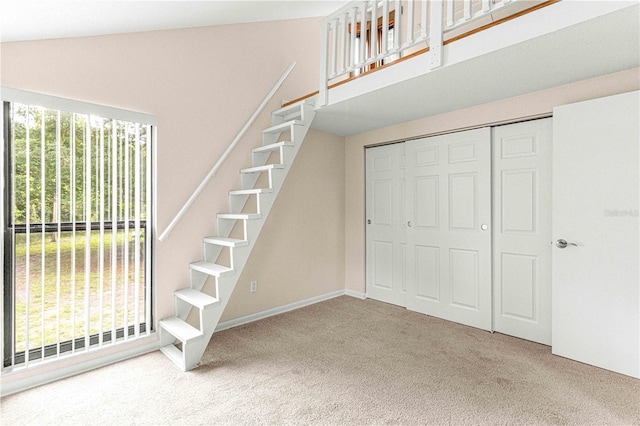 stairway with carpet floors and vaulted ceiling