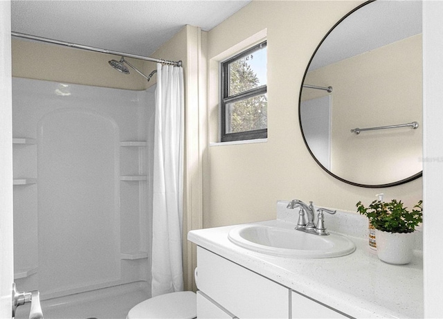 bathroom with toilet, vanity, and a shower with shower curtain