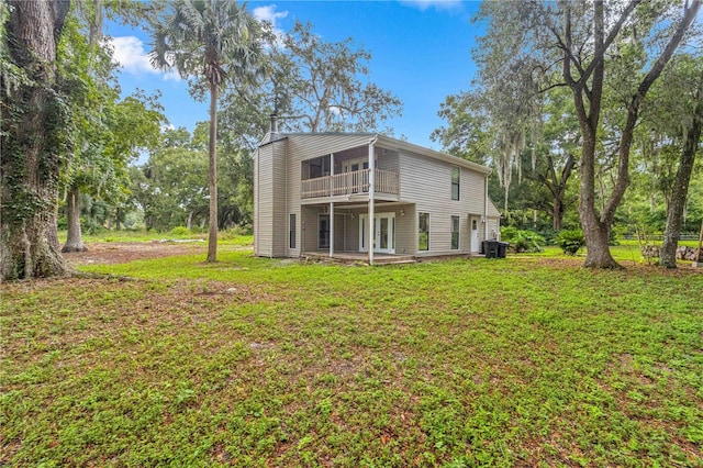 back of house with central AC and a yard