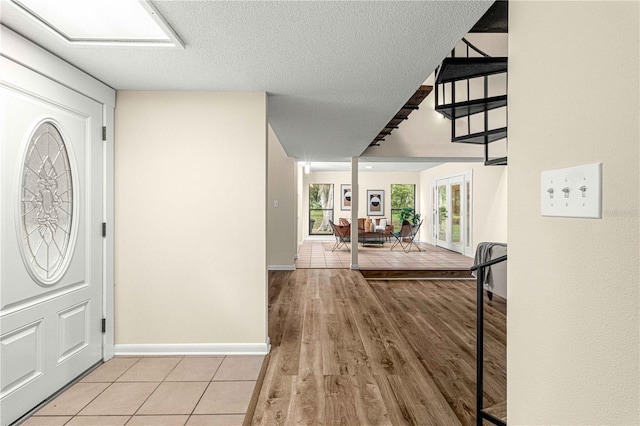 foyer entrance featuring a textured ceiling and light hardwood / wood-style flooring