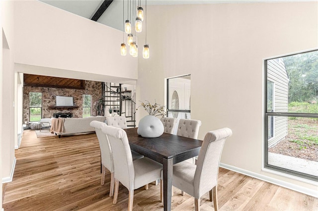 dining room with a wealth of natural light, light hardwood / wood-style floors, and high vaulted ceiling