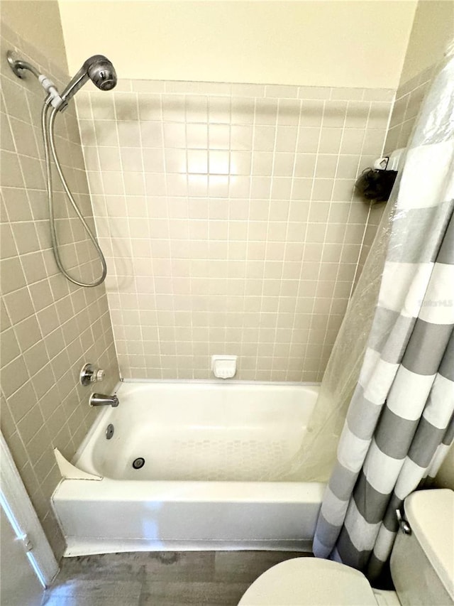 full bathroom with toilet, shower / bath combination with curtain, and wood finished floors