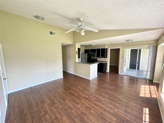 unfurnished living room with a textured ceiling, a ceiling fan, lofted ceiling, dark wood-type flooring, and visible vents