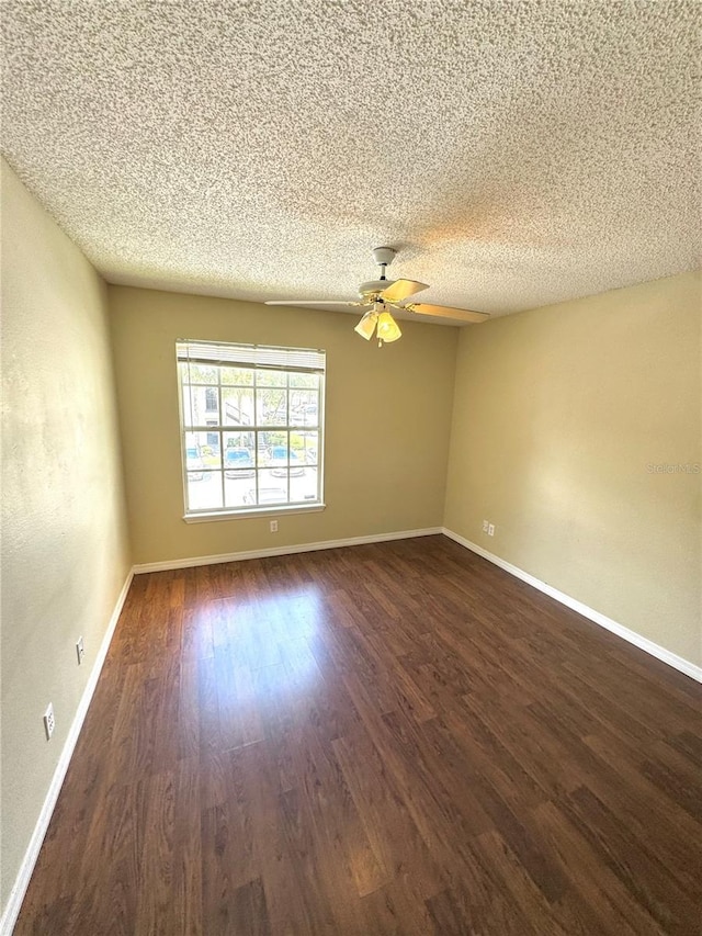 empty room featuring baseboards, a textured ceiling, dark wood-style flooring, and ceiling fan