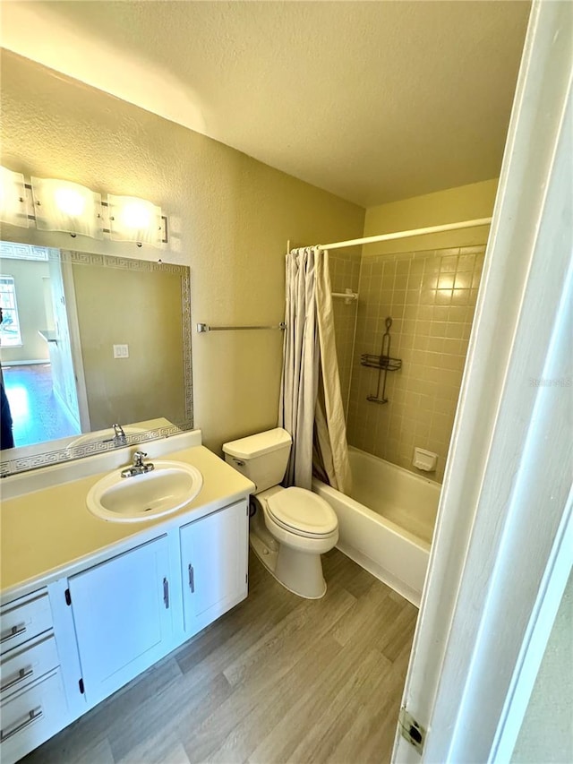 bathroom with a textured ceiling, vanity, toilet, and wood finished floors