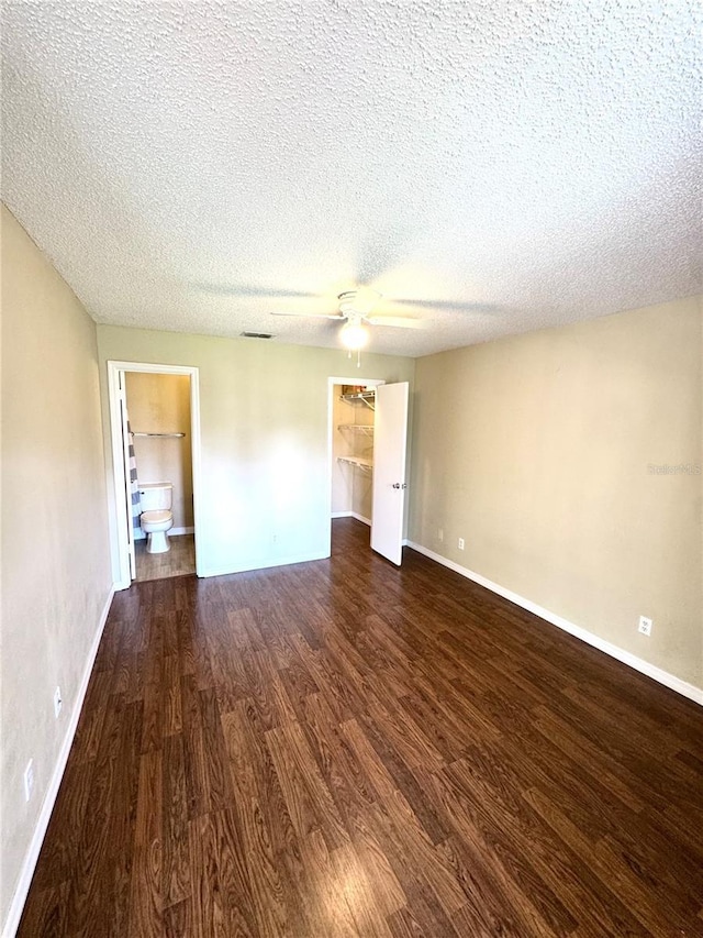 empty room featuring baseboards, a textured ceiling, ceiling fan, and wood finished floors