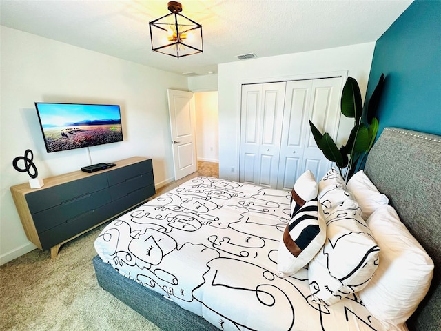 carpeted bedroom featuring a closet and an inviting chandelier