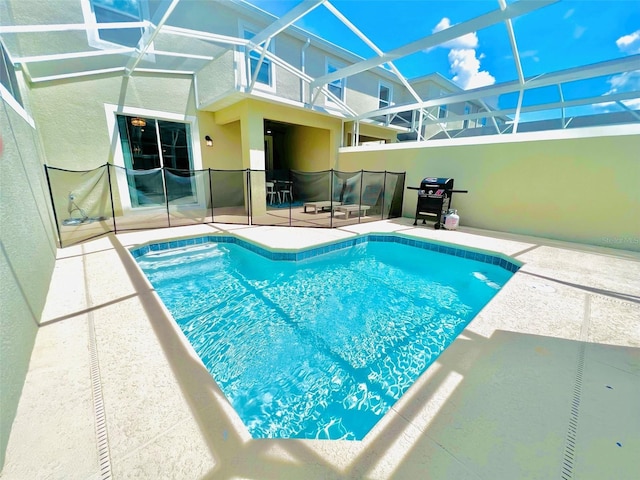 view of pool with area for grilling, a patio, and glass enclosure