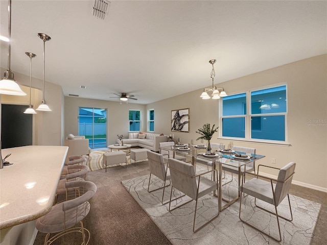 dining space with carpet and ceiling fan with notable chandelier