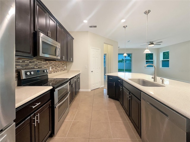 kitchen featuring backsplash, stainless steel appliances, ceiling fan, sink, and pendant lighting