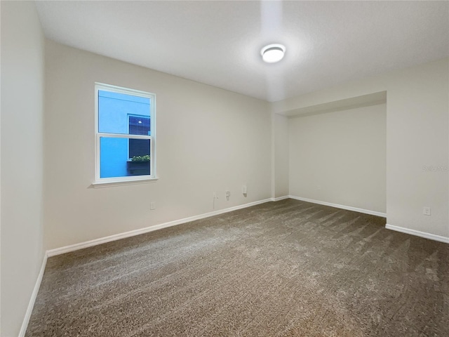 empty room with dark colored carpet